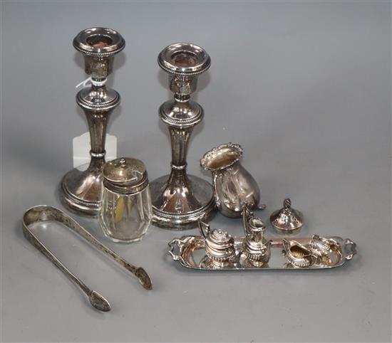 A pair of silver mounted candlesticks, two silver mounted condiments, a pair of sugar tongs and miniature tea set on tray